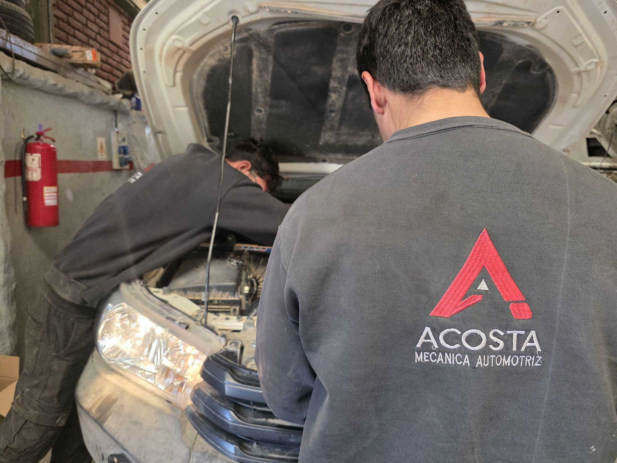 Uniforme bordado con el logo de Acosta Mecánica Automotriz